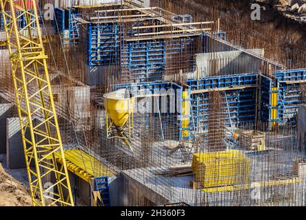 Installed formworks and iron rebars or reinforcing bar for reinforced concrete partitions at the construction site of a large residential building. Stock Photo