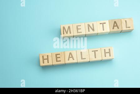 wooden cubes with the inscription mental health on a blue background. The concept of a state of well-being in which a person can fulfill his own poten Stock Photo