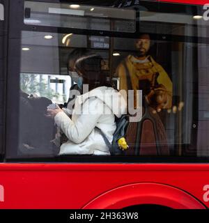 Candid Image Of A Woman Sitting On A London Bus Wearing Covid-19 Coronavirus Protective Mask Stock Photo