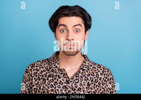 Portrait of attractive funky brunette childish guy holding breath isolated over vibrant blue color background Stock Photo