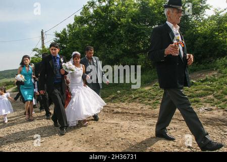 Mociu commune, Cluj-Napoca, Romania, June 6, 2009: A bride and a groom from a gypsy family, accompanied by their guest are passing on the street durin Stock Photo