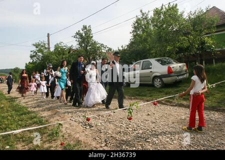 Mociu commune, Cluj-Napoca, Romania, June 6, 2009: A bride and a groom from a gypsy family, accompanied by their guest are passing on the street durin Stock Photo