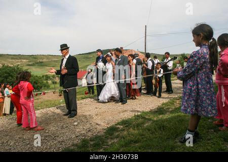 Mociu commune, Cluj-Napoca, Romania, June 6, 2009: A bride and a groom from a gypsy family, accompanied by their guest are passing on the street durin Stock Photo