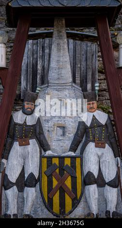 25 October 2021, Saxony, Pockau-Lengefeld: Two miners at a lime kiln can be seen on a relief in front of the historic Lengefeld lime works. The technical monument has been a selected site of the Unesco World Heritage Mining Region Erzgebirge since 2019 and is currently being restored at a cost of around 1.1 million euros. After completion of the first construction phase, it is planned that the museum will reopen next year. It is one of the most important monuments to the old binder industry in Europe. Here, the complete technological process from limestone marble quarrying to stone powder and Stock Photo