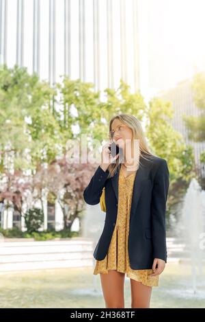 Young and beautiful businesswoman with glasses talking on the phone outside the office Stock Photo