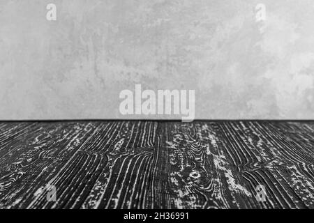 Empty black wooden surface against gray decorative plaster or concrete background. Mockup for design. Stock Photo
