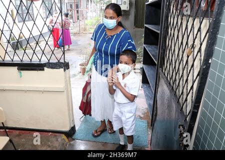 Colombo, Sri Lanka. 25th Oct, 2021. A parent takes her child to school in Colombo, Sri Lanka, Oct. 25, 2021. Primary schools across Sri Lanka re-opened for students on Monday after being shut for months due to a rapid spread of the COVID-19, officials said here. Credit: Ajith Perera/Xinhua/Alamy Live News Stock Photo