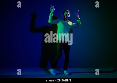 Full body photo of young man happy positive smile enjoy music nightclub dance hipster isolated over dark color background Stock Photo