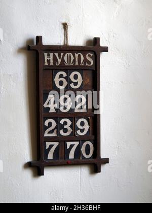 Hymn board in All Saints' Church, Spetchley, a redundant Anglican church adjacent to Spetchley Park, Worcestershire, listing hymns to be sung. Stock Photo