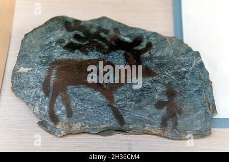 Famous prehistoric rock paintings. Drawings of ancient people on a blue stone. Stock Photo