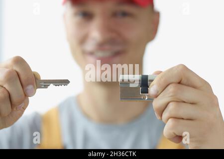 Young man in uniform holding keyhole and key closeup Stock Photo