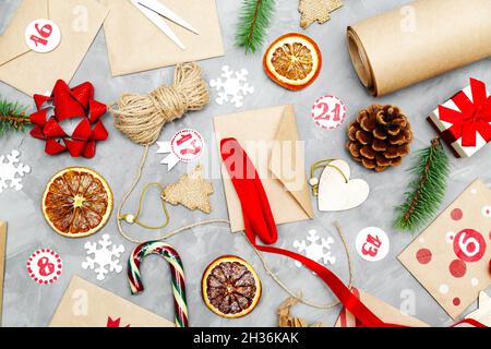 Preparing the Advent Calendar. Eco craft envelopes with gifts for children. Seasonal Christmas tradition. Flat lay, top view. Stock Photo