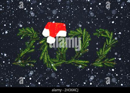Numbers 2022 made from fir branches. Snow. Dark background. New Year or Christmas background. Stock Photo