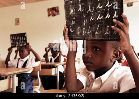 NIGER. NIAMEY. PUPILS AND THEIRS BOARDS DURING A LESSON IN THE CATHOLIC SCHOOL Stock Photo