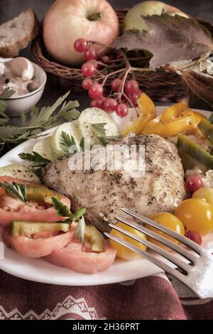 Baked chicken leg on a plate with vegetables Stock Photo