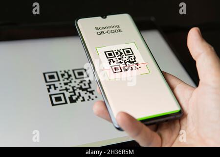 Scanning QR code with mobile smart phone. all the graphics on the screen are made up. checking the qr code on the mobile phone. Stock Photo