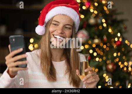 Happy girl in Santa hat posing for selfie
