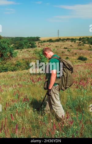 Male hand holding metal detector device above the ground Stock Photo ...