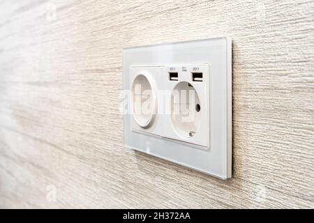 Modern power socket, with two usb charger ports on the white wall Stock Photo