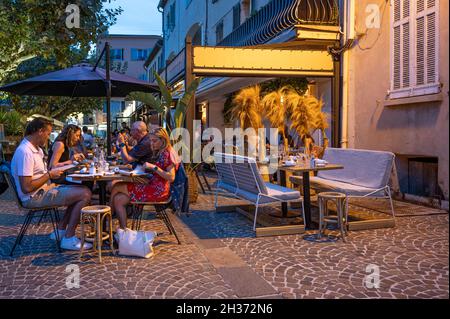 A summer evening in Sainte-Maxime, with peole strolling and dining in the restaurants of the seaside resort at the Côte d'Azur Stock Photo