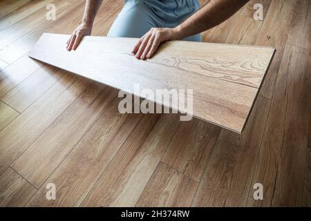 Man laying laminate flooring in a home. replacement of parquet on the floor Stock Photo