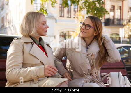 Happy mature woman enjoying talking to her female friend in the park Stock Photo