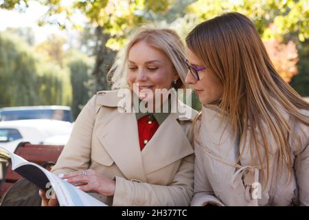 Middle aged woman studying in the park with her friend Stock Photo