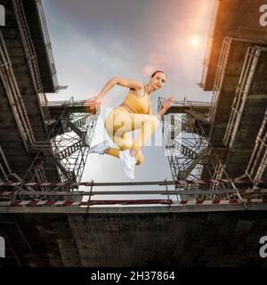 fit sporty woman running and jumping. Urban background. Free runner. Stock Photo