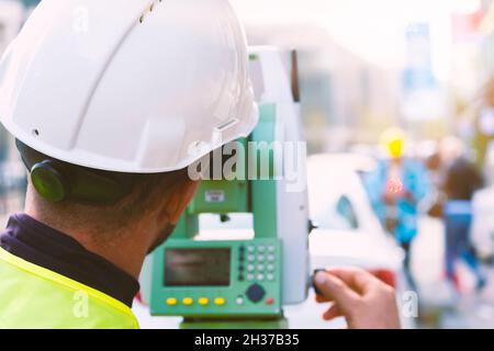 Engineer surveyor working with theodolite at road construction site Stock Photo