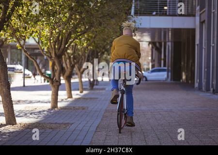 Albino african american man with dreadlocks riding bike Stock Photo