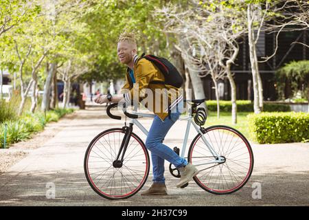 Portrait of smiling albino african american man with dreadlocks on bike Stock Photo