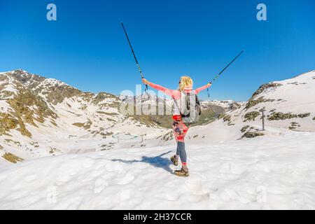 girl with trekking poles on top of Diavolezza col. Munt Pers and Piz Trovat of Switzerland in Graubunden canton. Stock Photo