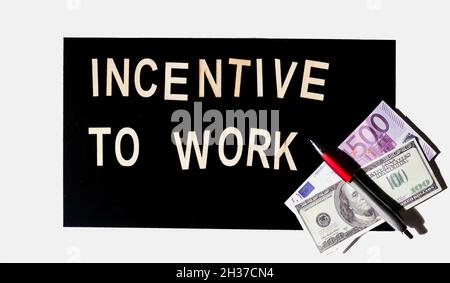 INCENTIVE TO WORK text is written on a black mirror background in wooden letters. Stock Photo