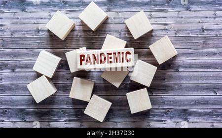 Pandemic, text is written on wooden blocks and gray table surface Stock Photo