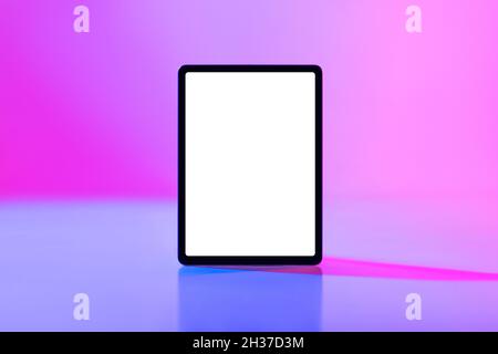 Modern tablet computer with mockup for application or website on blank white screen in neon light Stock Photo