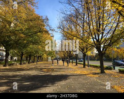 BERLIN, GERMANY - OCTOBER 24, 2021: Beautiful autumn day at Karl-Marx-Allee, a boulevard in Berlin on a sunny day in October. Golden Fall Colours. Lea