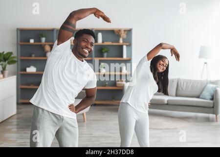 Young black couple doing arm stretch exercise together Stock Photo