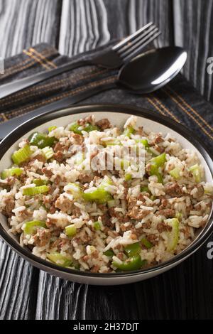 Dirty rice is a classic Cajun dish that is typically made with chicken livers and ground meat close-up in a plate on the table. Vertical Stock Photo