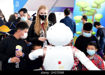 (211026) -- HEFEI, Oct. 26, 2021 (Xinhua) -- Ukrainian student Aly interacts with a robot at the 4th World Voice Expo in Hefei, capital of east China's Anhui Province, Oct. 24, 2021. Aly has been studying Chinese for seven years and now she is a graduate student at Anhui University. She has spent her time trying high-tech products at the World Voice Expo and believes that these products could make a better life for us. Companies and developers specializing in artificial intelligence (AI) and speech technology gathered in Hefei, capital of east China's Anhui Province on Monday for the 4th Wor Stock Photo