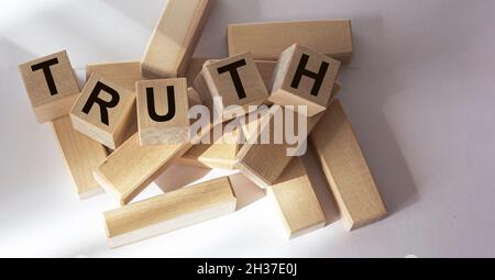 Truth - word from wooden blocks with letters, real facts truth concept, random letters around, white background Stock Photo