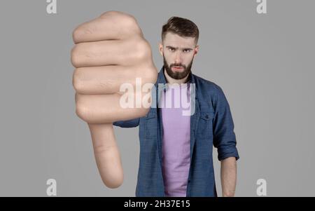 Angry bearded young man showing thumb down Stock Photo