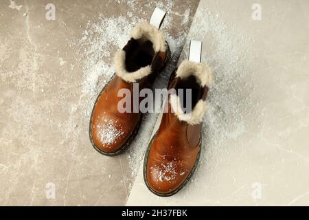 Boots with snow on two tone background. Stock Photo