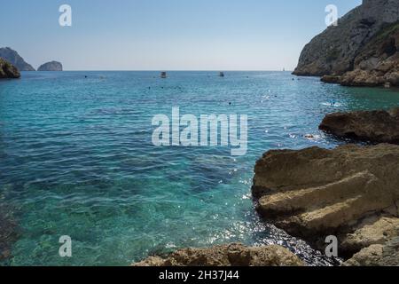 clear turquoise blue water and cliffs in a beautiful bay on the Mediterranean coast in Spain Stock Photo