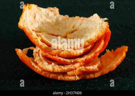 Orange peel of mandarin fruit shown on dark green background. Stock Photo