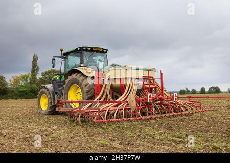 Tractor in a field sowing wheat seeds in the autumn. Much Hadham, Hertfordshire, UK. Stock Photo