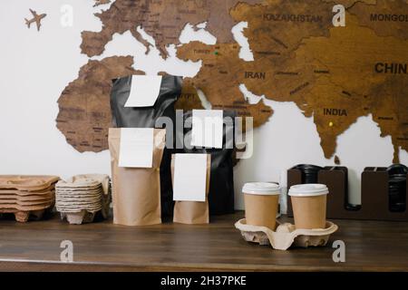 Disposable paper cups with coffee for takeaway food. Packages with coffee on counter for self-service, drink to go. Stock Photo