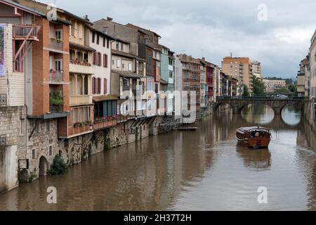 View of Castres, characteristic old French town with traditional houses and boat on Agout river. Small town as travel destination in Tarn department Stock Photo