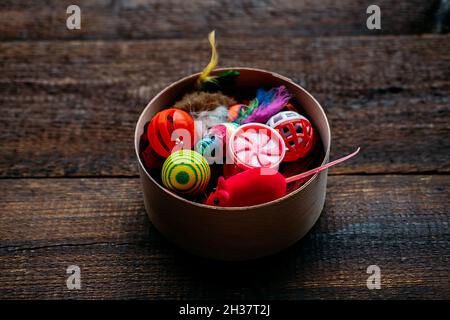 Pet toys. Many toys and balls for dog and cat on wooden background. Various balls, toy mouse, bones for playing and training Stock Photo
