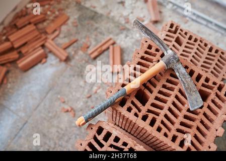 Pickaxe on some brick blocks in a house under construction Stock Photo