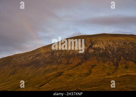 A rainbow forms over the mountains near Loch Ainort, Isle of Skye. Stock Photo